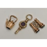 THREE LATE 19TH TO EARLY 20TH CENTURY CHARMS, to include a 9ct gold kettle, a pair of binoculars,