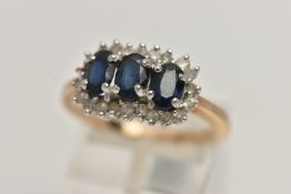 A 9CT GOLD SAPPHIRE AND DIAMOND CLUSTER RING, desinged with three oval cut deep blue sapphires, each