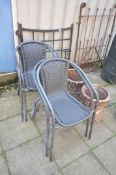 A SET OF FOUR METAL AND PLASTIC RATTAN STACKING GARDEN ARMCHAIRS