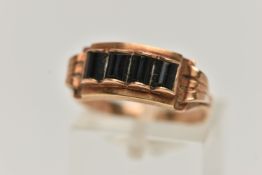 AN EARLY 20TH CENTURY RING, designed as a line of four black gem cylindrical panels, assessed as