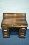 AN EARLY 20TH CENTURY OAK ROLL TOP DESK, containing an arrangement of drawers and shelves, over