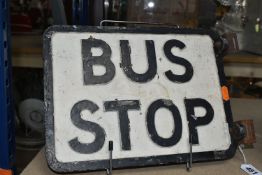 A CAST METAL DOUBLE SIDED BUS STOP SIGN, raised black lettering and edge on white background, ex