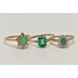 THREE GEM SET RINGS, the first an oval cut emerald set with a surround of round brilliant cut