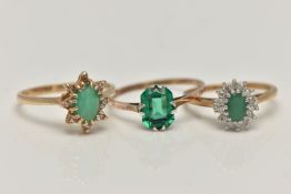 THREE GEM SET RINGS, the first an oval cut emerald set with a surround of round brilliant cut