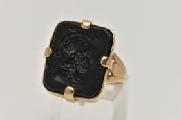 A YELLOW METAL INTAGLIO RING, rectangular onyx intaglio depicting a soldier in profile, four claw