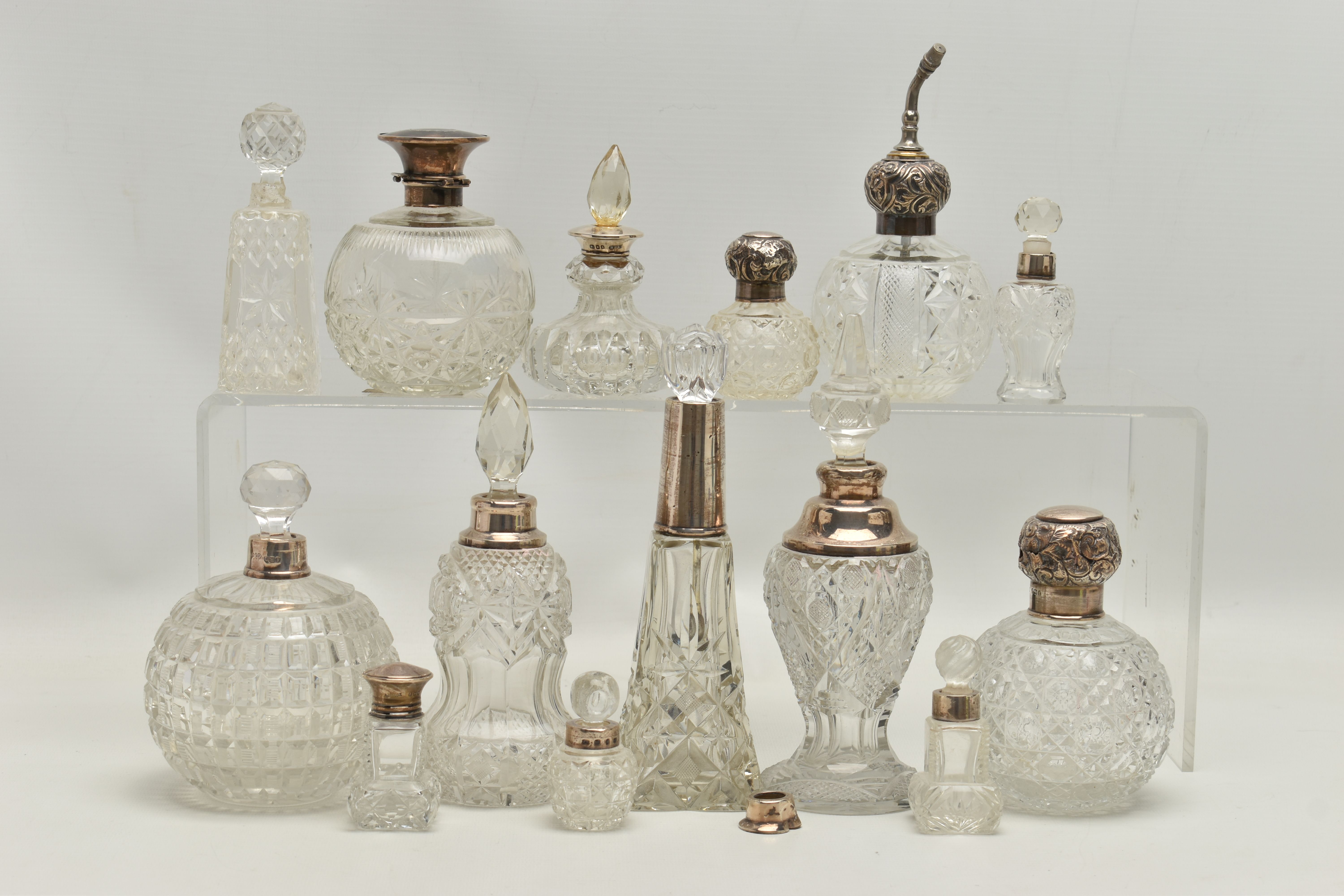 FOURTEEN LATE 19TH AND EARLY 20TH CENTURY SILVER MOUNTED SCENT BOTTLES, various shapes and sizes