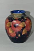 A MOORCROFT POTTERY BALUSTER VASE, tube lined Pomegranate pattern on a navy blue ground, painted and