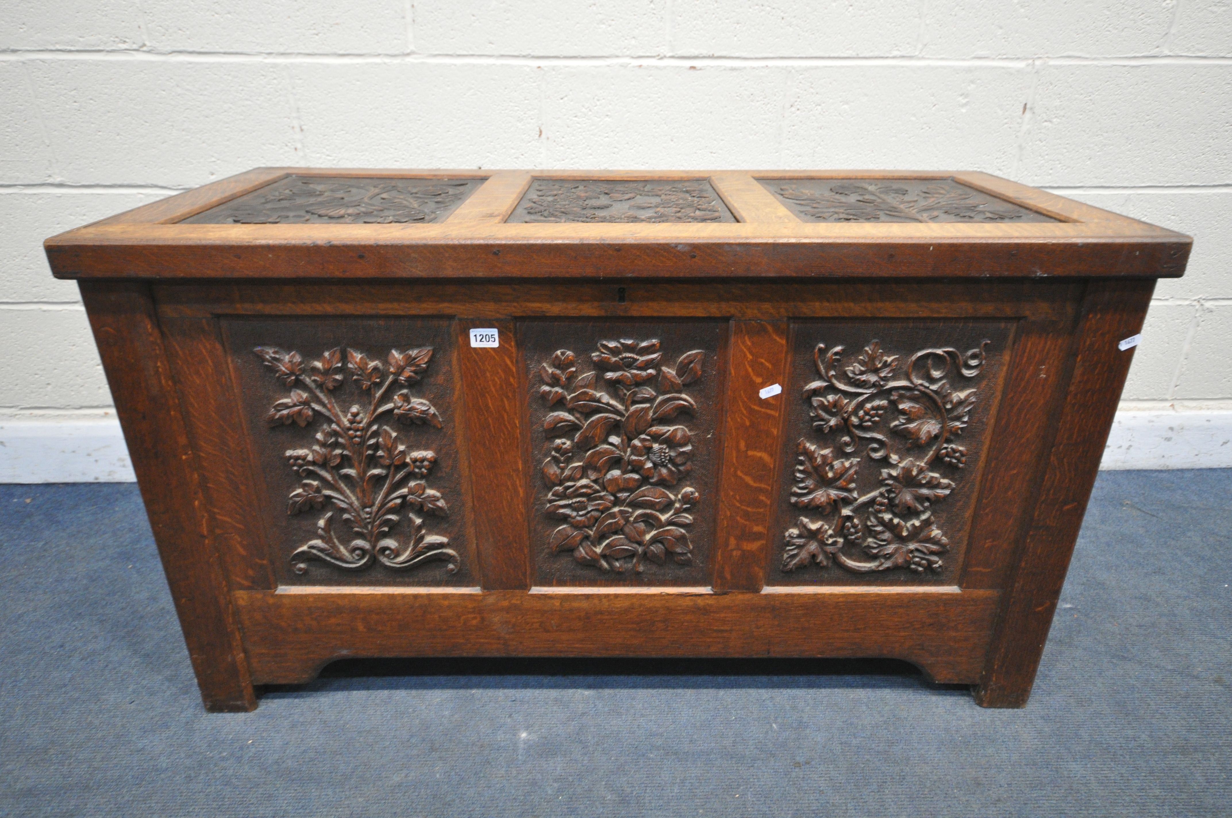 AN EARLY 20TH CENTURY OAK COFFER, decorated with nine foliate carved panels, width 122cm x depth