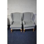 A PAIR OF GREY UPHOLSTERED WING BACK ARMCHAIRS, on beech legs (2)