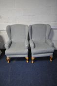 A PAIR OF GREY UPHOLSTERED WING BACK ARMCHAIRS, on beech legs (2)