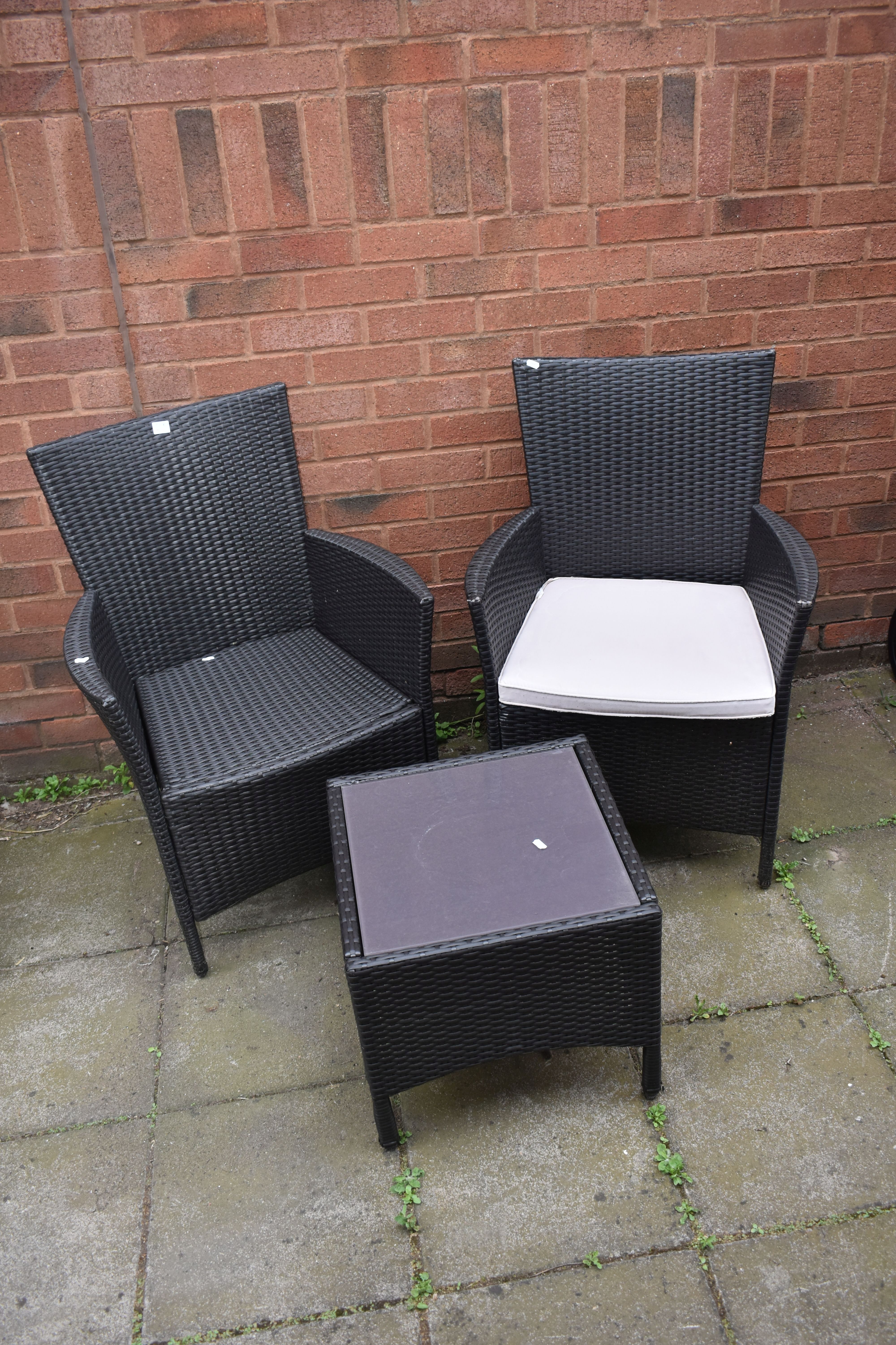 A PAIR OF PLASTIC RATTAN GARDEN ARMCHAIRS, and a matching coffee table (3)