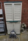 A PLASTIC TWO DOOR GARDEN CUPBOARD, along with a hose lock hose and reel (2)