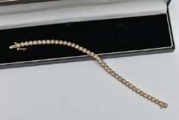 A 9CT GOLD DIAMOND LINE BRACELET, designed as a series of circular links each set with a small round