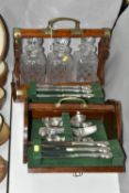 AN UNBRANDED EDWARDIAN OAK TANTULUS, with three decanters, original stoppers (one chipped at