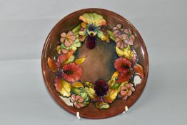 A MOORCROFT POTTERY ORCHID AND SPRING FLOWERS PATTERN PLATE, tube lined with red, pink, purple and