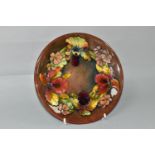 A MOORCROFT POTTERY ORCHID AND SPRING FLOWERS PATTERN PLATE, tube lined with red, pink, purple and