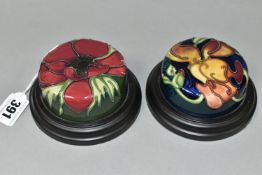 TWO MOORCROFT POTTERY PAPERWEIGHTS, set in wooden plinths, tube lined in Anemone and Miss Alice