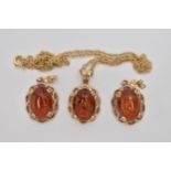 A PAIR OF COPAL AMBER EARRINGS AND A PENDANT, oval cabochon copal amber set in an open work yellow