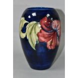 A MOORCROFT POTTERY VASE, of baluster form with a mauve and yellow Hibiscus pattern on a blue