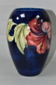 A MOORCROFT POTTERY VASE, of baluster form with a mauve and yellow Hibiscus pattern on a blue