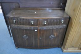 A 1940'S OAK BOWFRONT SIDEBOARD, with two drawers, above two cupboard doors, width 102cm x depth