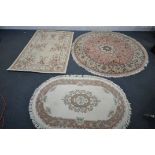 A SELECTION OF WOOLLEN RUGS, to include a circular pink floral rug, diameter 180cm, a rectangular
