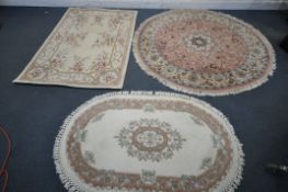 A SELECTION OF WOOLLEN RUGS, to include a circular pink floral rug, diameter 180cm, a rectangular