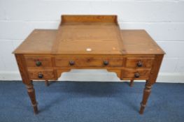 A VICTORIAN PITCH PINE WRITING DESK, with a hinged slopped centre, five drawers on turned legs,