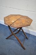 AN EARLY 20TH CENTURY CARVED OAK FOLDING CAMPAIGN TABLE, diameter 52cm x height 54cm (condition