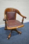 AN EARLY TO MID 20TH CENTURY OAK SWIVEL OFFICE CHAIR, with red leatherette back and seat (