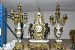 AN ITALIAN BRASS AND MARBLE CLOCK GARNITURE, modelled with a pair of fauns holding a garland, the