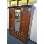 AN EDWARDIAN MAHOGANY TWO DOOR WARDROBE, with a central bevelled edge mirror, over a base with two