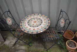 A CIRCULAR WEATHERED METAL TILE TOP FOLDING GARDEN TABLE, and two chairs (condition report: -seat