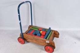 A TRI-ANG BABY WALKER, wooden construction with red painted wheels and black tyres, blue handle with