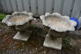 A PAIR OF WEATHERED COMPOSITE URNS, of foliate design, on a separate base, diameter 48cm x height