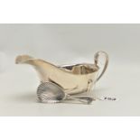 A SILVER GRAVY BOAT AND A CADDY SPOON, polished form with wavy rim and scrolling handle, raised on