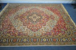 A LARGE WOOLLEN HEREKE TYPE RUG, with a red and a cream field, 348cm x 251cm (condition report: - in