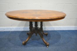 A VICTORIAN WALNUT AND MARQUETRY INLAID OVAL TILT TOP LOO TABLE, with four foliate carved legs,