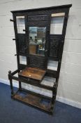 AN EARLY 20TH CENTURY CARVED OAK HALLSTAND, with ten hooks flanking a bevelled edge mirror, single