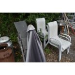 A SET OF FOUR FOLDING GARDEN CHAIRS, along with a parasol and a set of four cream stacking garden