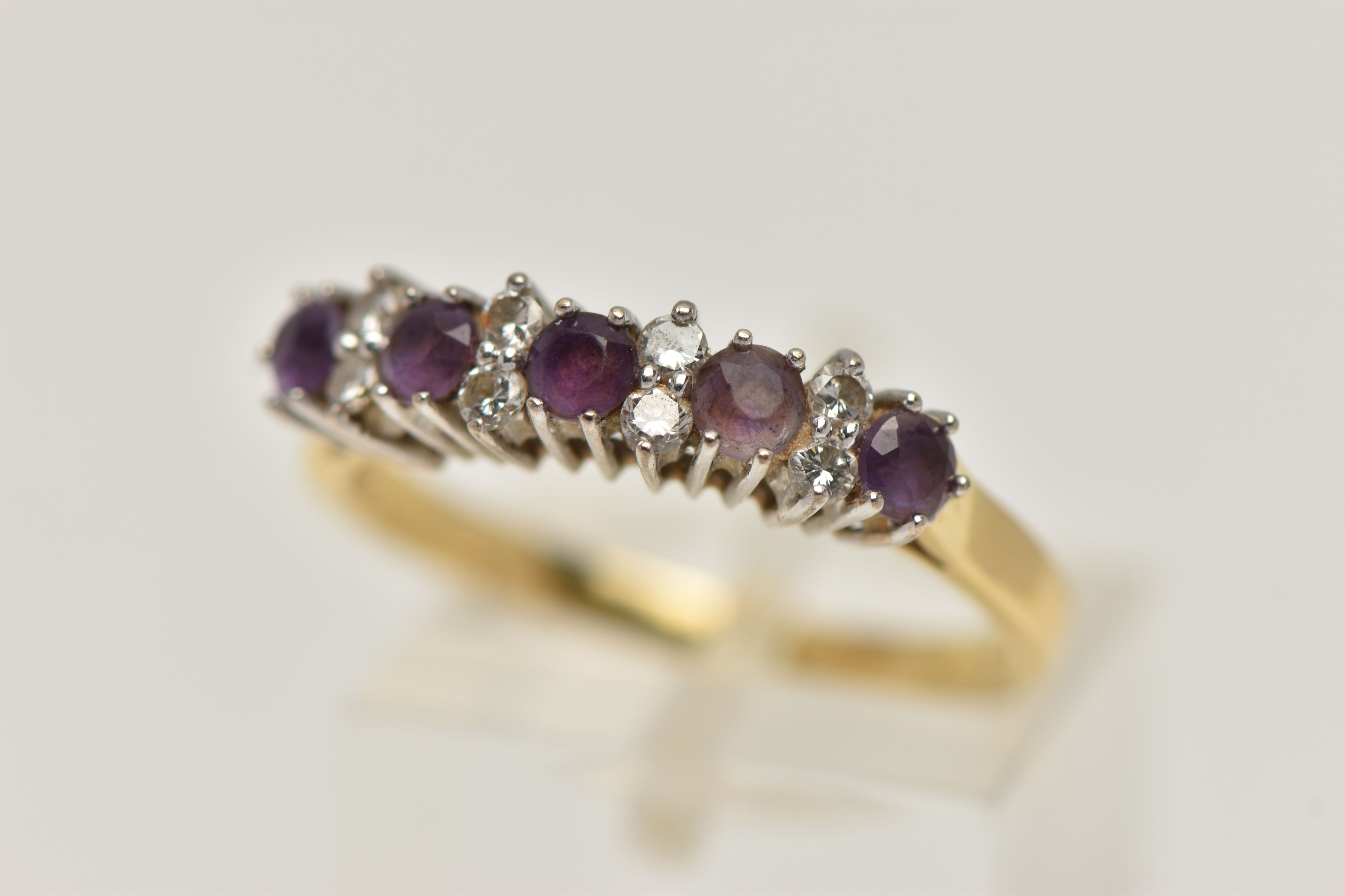 A 18CT GOLD DIAMOND AND AMETHYST RING, five circular cut amethyst stones interspaced with round