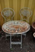 A WROUGHT IRON FOLDING THREE PIECE GARDEN BISTRO SET, comprising an oval table, with pierced foliate