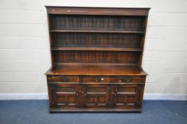 A REPRODUCTION SOLID OAK DRESSER, the top with a two tier plate rack, the base with three drawers