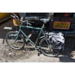 A GREEN GENTS MONGOOSE BICYCLE, with a 22inch frame and two rear bags (condition - handles sticky,