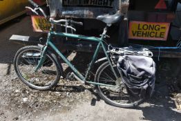 A GREEN GENTS MONGOOSE BICYCLE, with a 22inch frame and two rear bags (condition - handles sticky,