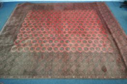 A LARGE WOOLLEN TEKKE RUG, with a central red field and multi strap boarder, 340cm x 255cm (
