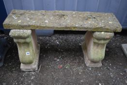 A COMPOSITE TWIN PEDESTAL GARDEN BENCH, the legs with a floral crest to the centre, length 90cm x