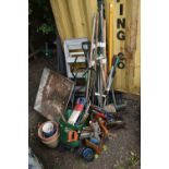 A VARIETY OF GARDEN TOOLS, to include a wheelbarrow, seed spreader, shovels, brushes, forks,