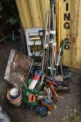 A VARIETY OF GARDEN TOOLS, to include a wheelbarrow, seed spreader, shovels, brushes, forks,