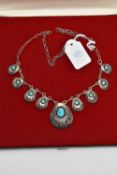 A BOXED WHITE METAL TURQUOISE NECKLACE, designed with a row of nine pierced pendants each set with
